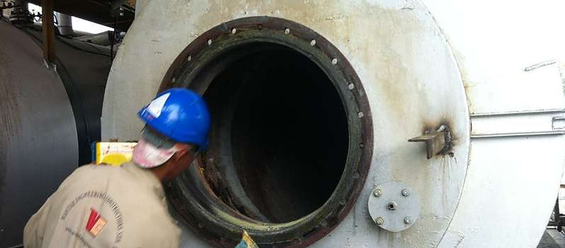 Worker inspecting vessel manway